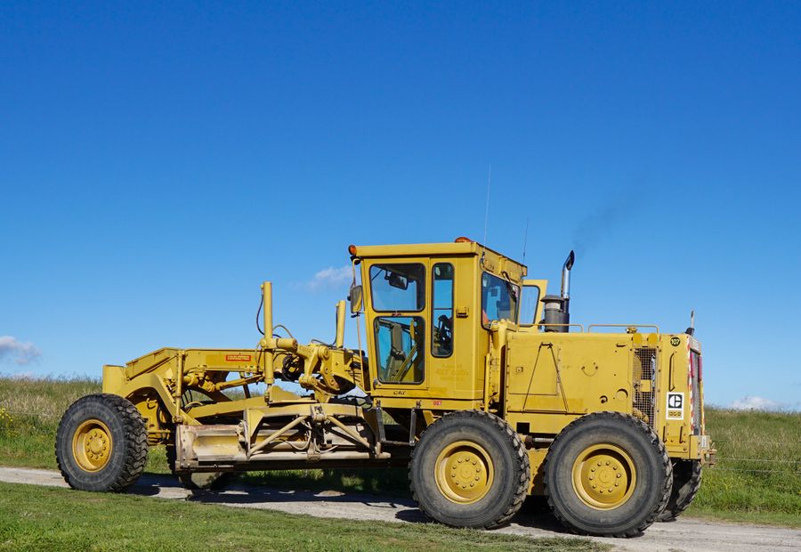 Motor grader shaping a gravel lane on an Ozarks acreage